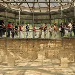 Scena di turisti in visita al triclinium